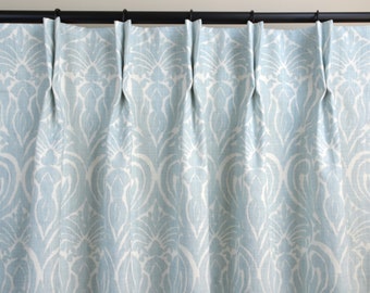 May include: Pale blue curtains with a white damask pattern. The curtains are hung on a black curtain rod.