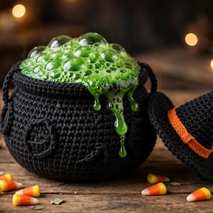 Puede incluir: Un caldero negro de ganchillo lleno de un líquido verde brillante y burbujeante que se desborda por el lateral. Junto al caldero hay un sombrero de bruja negro de ganchillo con una banda naranja. La escena incluye pequeñas calabazas.