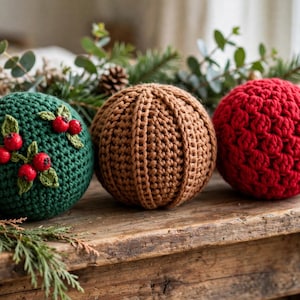 Handmade crocheted Christmas balls in deep green with berry applique cinnamon rib and scarlet puff on a wooden mantel