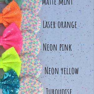 K&ouml;nnte beinhalten: F&uuml;nf Paare farbenfroher, mit Pailletten besetzter Minnie Mouse Ohren mit Schleifen. Die Farben sind mattes Mint, Laser Orange, Neon Pink, Neon Gelb und T&uuml;rkis.