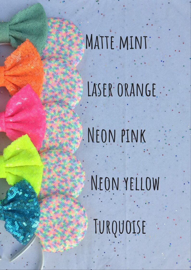 K&ouml;nnte beinhalten: F&uuml;nf Paare farbenfroher, mit Pailletten besetzter Minnie Mouse Ohren mit Schleifen. Die Farben sind mattes Mint, Laser Orange, Neon Pink, Neon Gelb und T&uuml;rkis.
