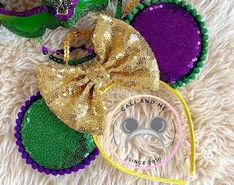 Könnte beinhalten: Lila, grün und goldfarbene, mit Pailletten besetzte Minnie Mouse Ohren mit einem gelben Haarreif. Der Haarreif trägt den Text "Cali and Me Since 2010".