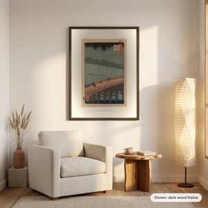 Hiroshige's Sudden Shower in a dark frame on a living room wall above an armchair