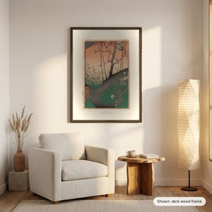 Hiroshige's Plum Park in Kameido in a dark frame on a living room wall above an armchair