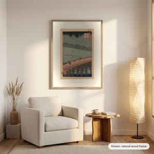Hiroshige's Sudden Shower in a natural wood frame on a living room wall above an armchair