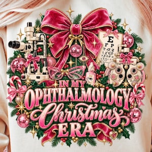 Könnte beinhalten: Ein beiges Sweatshirt mit Rundhalsausschnitt und einem festlichen Motiv aus einem Kranz mit rosa Schleifen, Weihnachtskugeln, einem Sehtest-Diagramm und medizinischen Geräten sowie dem Schriftzug "IN MY OPHTHALMOLOGY CHRISTMAS ERA" in Rosa und Weiß.