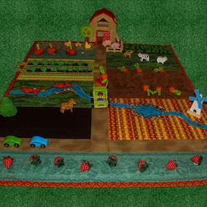 Könnte beinhalten: Eine farbenfrohe Spielmatte mit Farm-Thema. Die Matte zeigt einen roten Stall, einen grünen Traktor, einen blauen Fluss, eine Windmühle und verschiedene Farmtiere. Die Matte ist von einem roten und orangenen Rand umgeben.