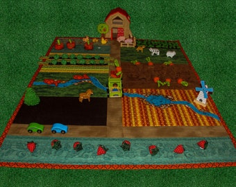 May include: A colourful play mat with a farm theme. The mat features a red barn, a green tractor, a blue river, a windmill, and various farm animals. The mat is surrounded by a red and orange border.