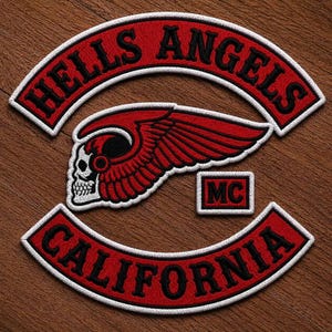 May include: An embroidered patch set featuring a curved top rocker with the text HELLS ANGELS in black, a central winged skull emblem in red and white, a small rectangular MC patch, and a curved bottom rocker with the text CALIFORNIA.