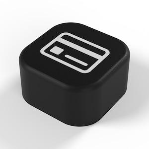 Peut inclure: Un objet noir de forme carrée aux coins arrondis, arborant une icône graphique blanche représentant une carte de paiement sur sa face supérieure. L'objet présente une finition mate lisse et une forme solide et compacte, claire et simple.