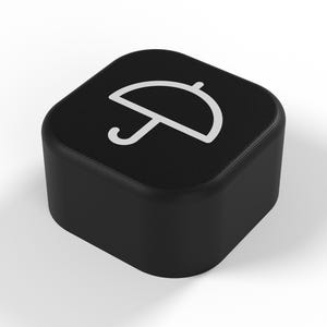 Peut inclure: Un bouton noir de forme carrée aux coins arrondis, arborant une icône en ligne blanche représentant un parapluie centrée sur la surface supérieure. L'objet présente une finition mate lisse et un profil épais, offrant un design graphique épuré.