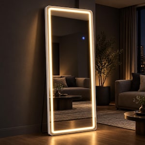 May include: A tall, rectangular floor mirror with a white frame and an integrated LED light strip that glows with a warm yellow hue. The mirror features a small, circular blue touch-sensitive power button on the right side of the glass surface.