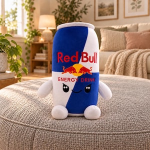 May include: A plush toy shaped like a Red Bull energy drink can, featuring the iconic blue and white color scheme, the Red Bull logo with two red bulls and a yellow sun, and a cute face with black eyes and a small smile, plus two arms and legs.