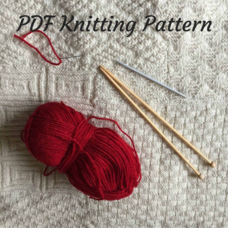 K&ouml;nnte beinhalten: Rotes Strickgarn, zwei Stricknadeln aus Holz und eine wei&szlig;e Stricknadel auf einem wei&szlig;en gestrickten Stoffhintergrund. Der Text "PDF Knitting Pattern" befindet sich oben im Bild.