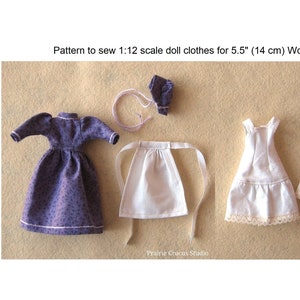 May include: A set of doll clothes for a 5.5 inch (14 cm) doll. The set includes a purple dress, a white apron, a white petticoat, and white bloomers. The clothes are made of fabric and have a vintage style.
