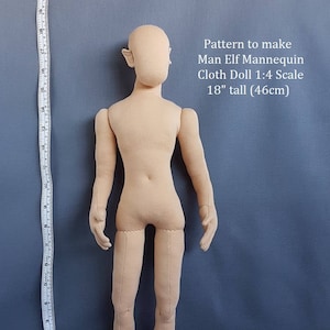 May include: A beige cloth doll mannequin in the shape of a man with pointed ears. The doll is 18 inches tall and is standing on a blue surface. The text "Pattern to make Man Elf Mannequin Cloth Doll 1:4 Scale 18" tall (46cm)" is printed above the doll. The text "Prairie Crocus Studio" is printed below the doll.