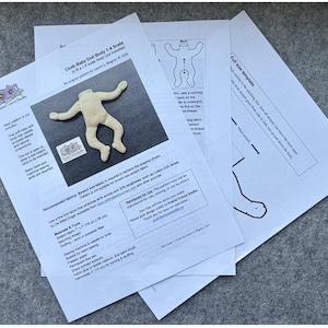 May include: A collection of paper patterns for a cloth baby doll body, including a 1/4 scale head. The patterns feature a beige doll body and instructions. The text includes "Cloth Baby Doll Body 1:4 Scale" and "Prairie Crocus Studio."