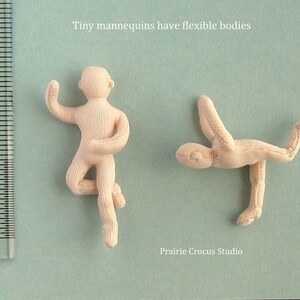 May include: Two small, flexible, beige mannequins posed in different positions. The mannequins are made of fabric and are about 2 inches tall. The text "Tiny mannequins have flexible bodies" is above the mannequins. The text "Prairie Crocus Studio" is below the mannequins.
