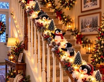 Peut inclure: Une guirlande d'escalier ornée de figurines de pingouins en peluche portant des écharpes, agrémentée de sapins miniatures, de baies rouges, de pommes de pin et de guirlandes lumineuses blanc chaud sur une rampe en bois blanc.
