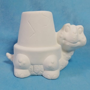 May include: White ceramic turtle planter with a removable pot. The turtle has a detailed shell and a friendly face.