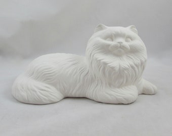 May include: White ceramic figurine of a longhaired cat lying down. The cat has a fluffy tail and a sweet expression.