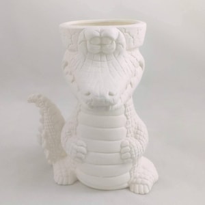 May include: White ceramic alligator planter with a textured surface. The planter has a wide opening at the top for planting.