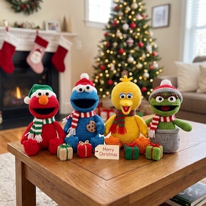May include: Four crocheted Sesame Street character dolls including Elmo, Cookie Monster, Big Bird, and Oscar the Grouch. Each wears a festive hat and scarf. Small crocheted gift boxes sit in front with a tag reading Merry Christmas.