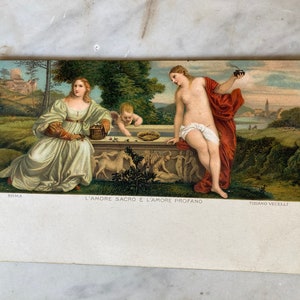 May include: Vintage postcard featuring a Renaissance-style painting. The artwork depicts two women and a cherub near a stone structure, with a landscape background. Text at the bottom reads "L'AMORE SACRO E L'AMORE PROFANO" and "TIZIANO VECELLI".