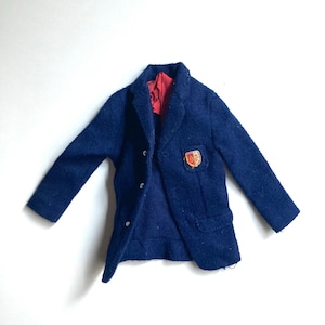 May include: A vintage navy blue blazer with a red lining and a small emblem on the front. The blazer has three buttons and two pockets. This classic jacket is a timeless piece of apparel.
