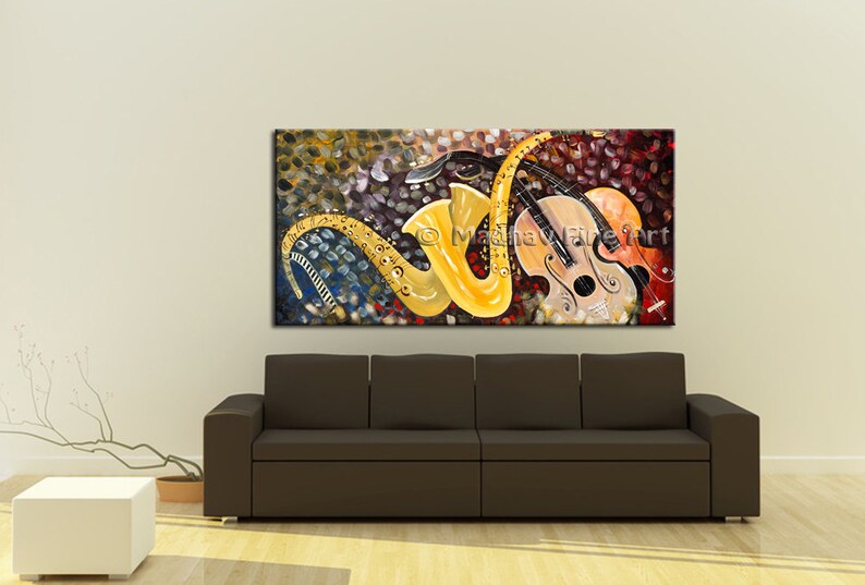 May include: Abstract painting of a yellow saxophone and a brown violin on a colorful background with musical notes. The painting is framed and hanging on a wall above a brown couch.