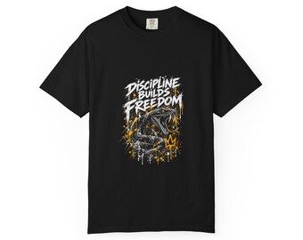 Könnte beinhalten: Ein schwarzes T-Shirt mit kurzen Ärmeln und einem Grafikdruck einer Schlange mit offenem Maul. Der Text "DISCIPLINE BUILDS FREEDOM" ist in Weiß darüber gedruckt, ergänzt durch gelbe und weiße Farbspritzer sowie eine kleine Krone.