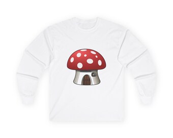 Peut inclure: Un t-shirt blanc à manches longues avec un motif centré représentant un champignon rouge à pois blancs. Le pied du champignon est dessiné comme une petite maison avec une porte arquée marron et une petite fenêtre sur le côté droit.