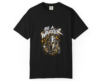 Könnte beinhalten: Ein schwarzes Kurzarm-T-Shirt mit einem Grafikdruck eines spartanischen Helms und dem Text BE A WARRIOR in weißer Schrift. Das Design enthält gelbe und weiße Farbspritzer, die die Helmabbildung umgeben.