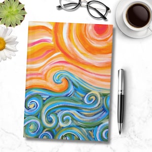 Könnte beinhalten: Ein farbenfroher Notizbuchumschlag mit einem gemalten Design einer Sonne und Wellen. Die Sonne ist orange und gelb mit weißen und rosa Streifen. Die Wellen sind blau, grün und weiß mit einem wirbelnden Muster.