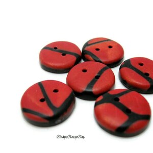 May include: Six red and black patterned buttons with two holes each. The buttons are made of polymer clay and have a glossy finish.