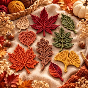 May include: A collection of crocheted leaves in various shapes and autumn colors, including red, orange, yellow, brown, and green. The set features maple, oak, and ginkgo leaf designs, accompanied by small acorns and dried floral accents.
