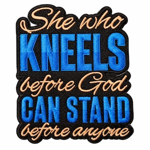 May include: A black embroidered patch featuring the text She who KNEELS before God CAN STAND before anyone. The words She who, before God, and before anyone are in a light tan script, while KNEELS and CAN STAND are in bold blue block letters.
