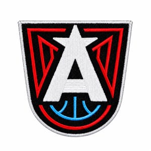 May include: A shield-shaped embroidered patch featuring a large white letter A centered over a black background. The design includes red geometric lines forming a frame around the letter and a light blue curved line at the bottom base.