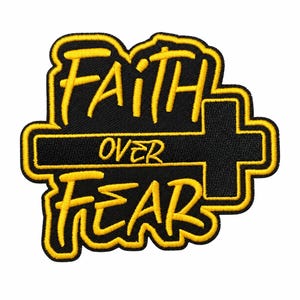 May include: An embroidered patch featuring the text FAITH OVER FEAR in yellow thread against a black background. The word OVER is positioned across a horizontal cross shape, with FAITH above and FEAR below, all outlined in yellow.