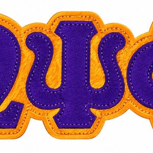 May include: A purple and gold embroidered patch featuring the Greek letters Omega, Psi, and Phi. The letters are rendered in a deep purple fabric with a textured gold border, showcasing detailed stitching along the edges of each character.