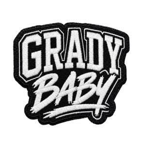 May include: A black and white embroidered patch featuring the text "GRADY" in a bold, block-style font on the top line and the word "BABY" in a stylized, script-like font on the bottom line, all set against a solid black background.