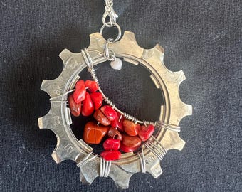 Luna de coral en un collar con engranajes de bicicleta