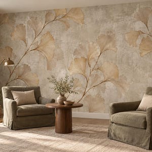 Könnte beinhalten: Ein Wandbild mit großen, beigen und braunen Ginkgoblatt-Illustrationen auf einem strukturierten, neutralen Hintergrund. Das Design erstreckt sich über die gesamte Wand und zeigt zarte, fließende Zweige mit fächerförmigen Blättern in erdigen Tönen.