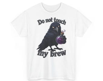 Ein mürrischer Cartoon-Rabe, der in einem chaotischen Hexenzimmer eine rauchende Zaubertrankflasche umklammert – Lustiges Halloween-T-Shirt mit Grafik.