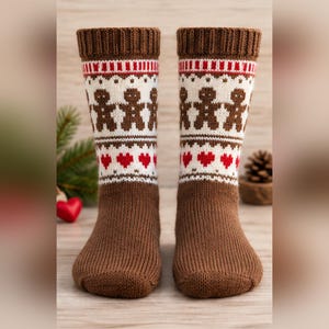 May include: A pair of brown knit socks featuring a ribbed cuff and a patterned band with white, red, and brown gingerbread man figures and red heart shapes. The socks have a solid brown foot section and a textured, knitted construction.