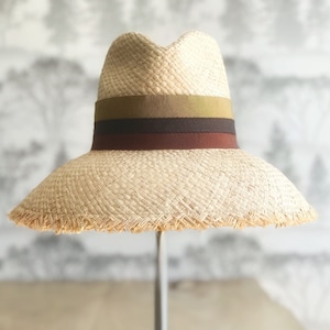 Rich earth tone striped natural raffia straw sun hat with wide bell shaped brim with fringed edge