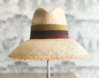 Rich earth tone striped natural raffia straw sun hat with wide bell shaped brim with fringed edge