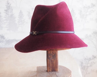 Camille:  Burgundy velour felt asymmetrical fedora with hand dyed burgundy leather trim and antique brass finding.