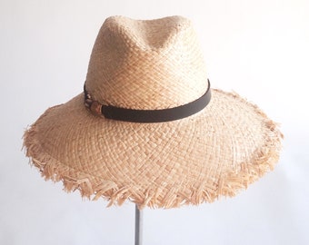 June II: Doubled natural raffia trilby crown with fray edge floppy brim and bamboo finding with chocolate leather trim