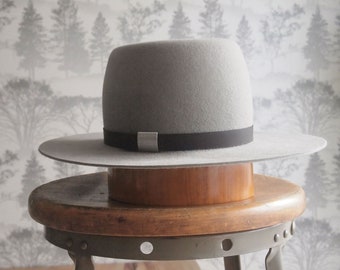 Reese: Unisex taupe barrel crown and flat brimmed fur felt hat with matte chocolate leather trim and silver detail